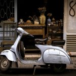 white and black motor scooter parked near building