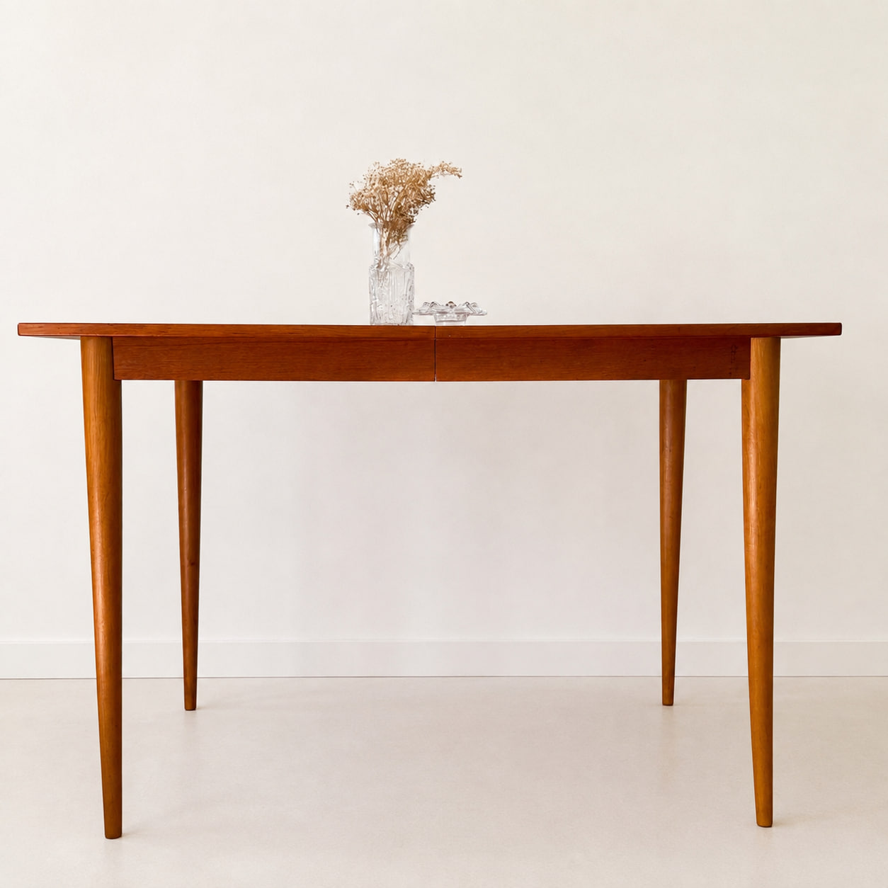 Vintage matbord i teak från 1960-talet med klassisk skandinavisk design och avsmalnande ben. Mått B 120 × D 80 × H 74 cm.