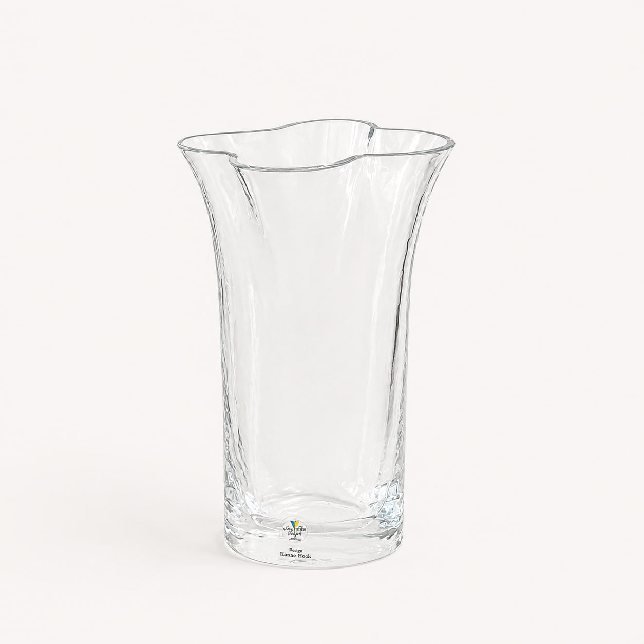 Stilren vas i klarglas, formgiven av Renate Stock för SEA Glasbruk. Organisk form med dekorativt vågig mynning. Helt oanvänd med originaletikett kvar. Höjd ca 20 cm.